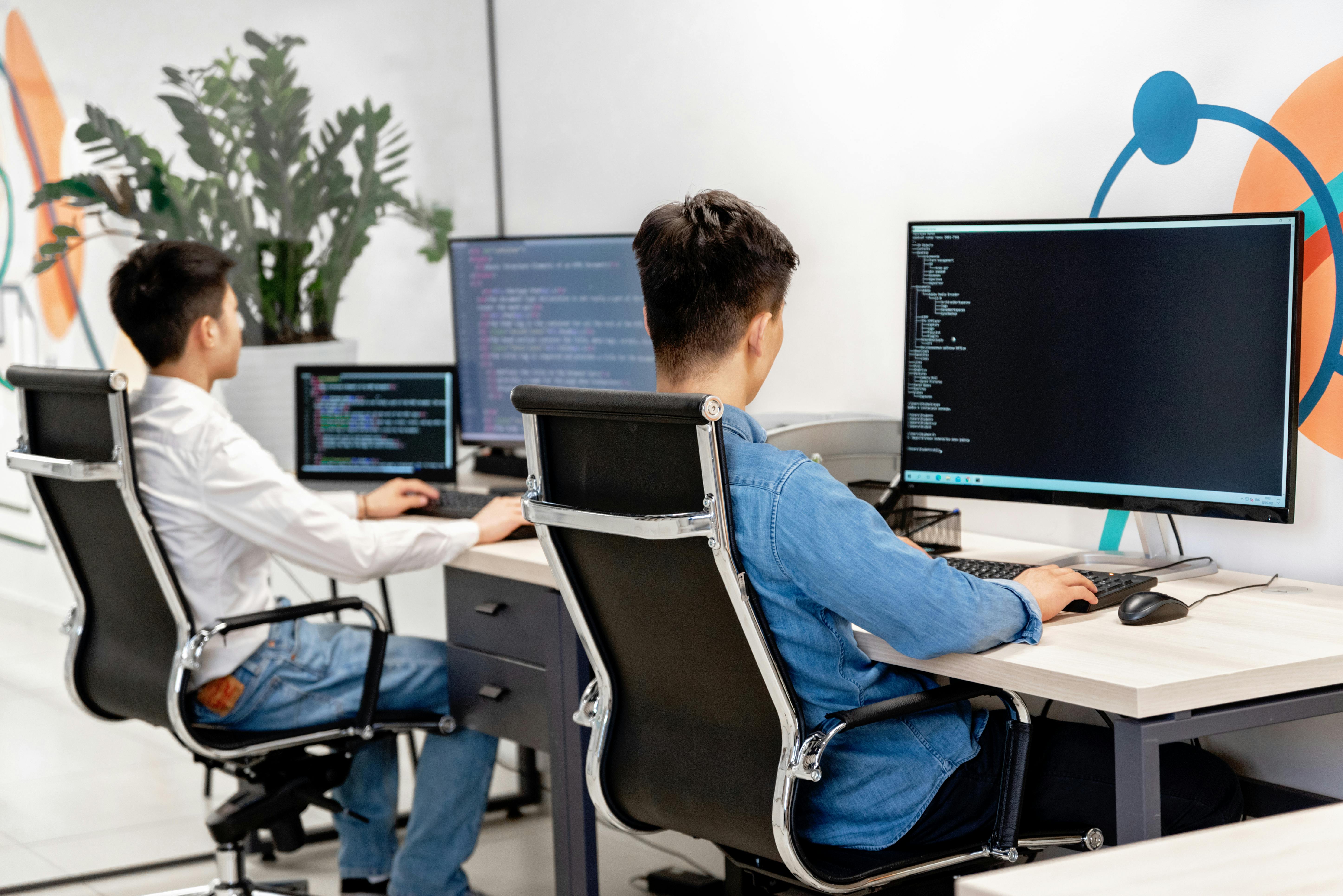 Software developers working on custom applications with multiple monitors